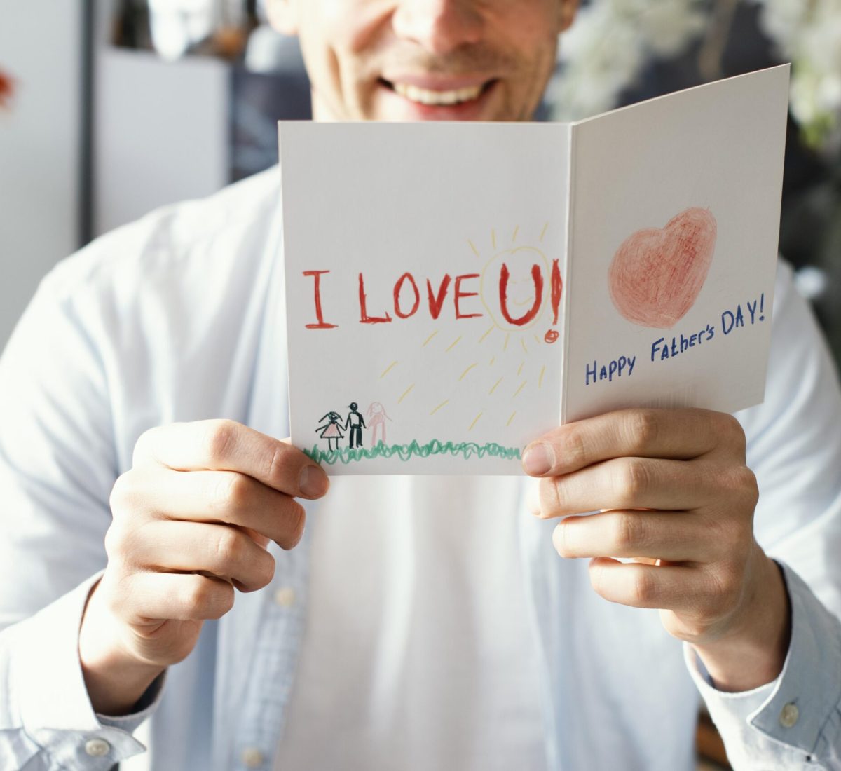 front-view-of-smiley-father-reading-his-father-s-day-card