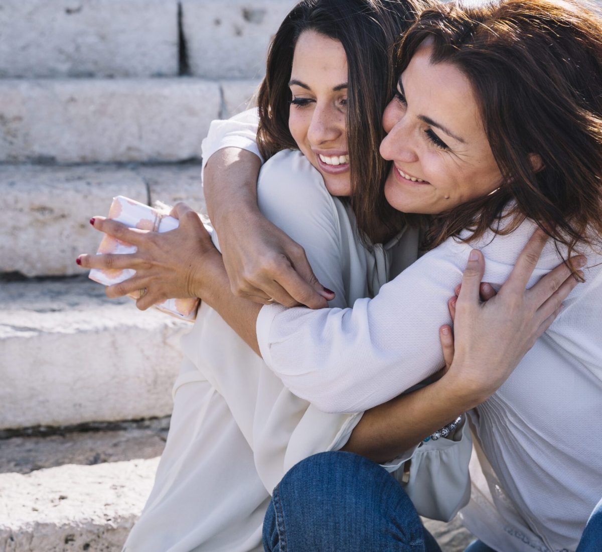 mother-with-gift-hugging-woman